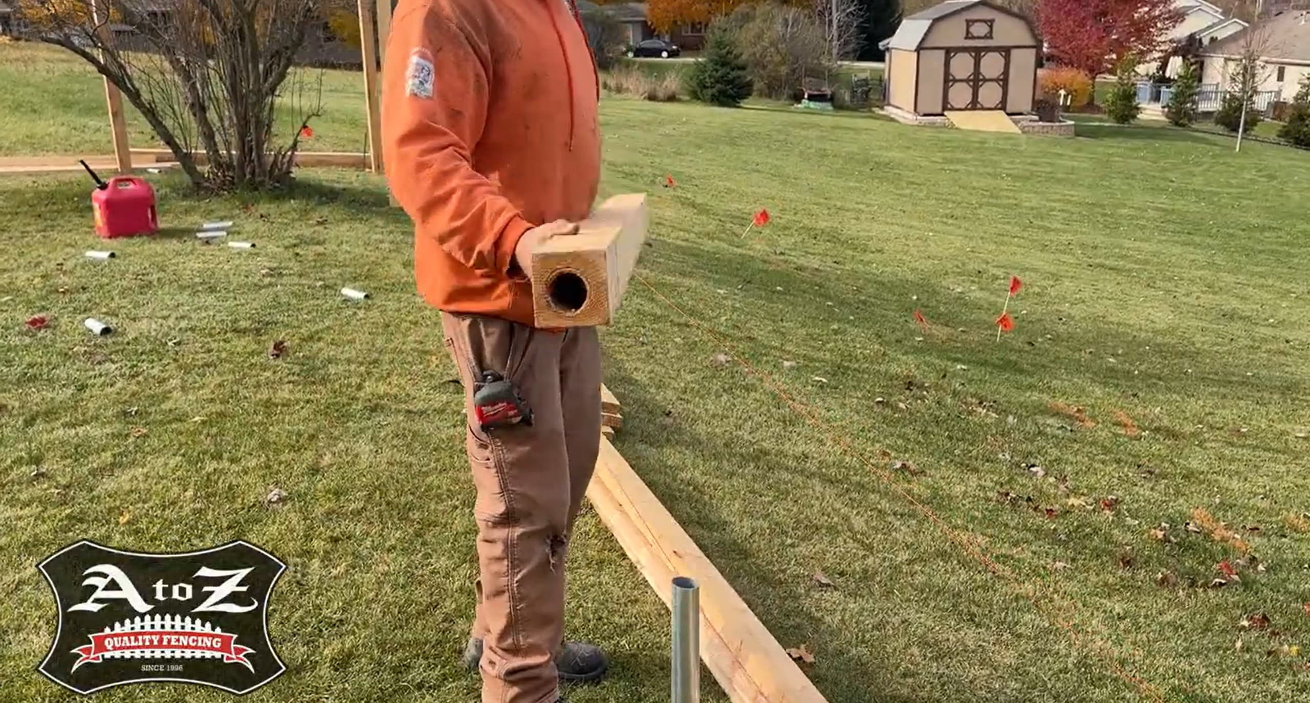 fence installation guide cover photo: picture of cedar fence being installed with a bored cedar post